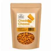 A stand-up kraft paper pouch of Martin's Handmade Cheddar Cheese Mini Pretzel Bits, featuring a clear window at the bottom showing the golden-brown pretzel pieces inside.