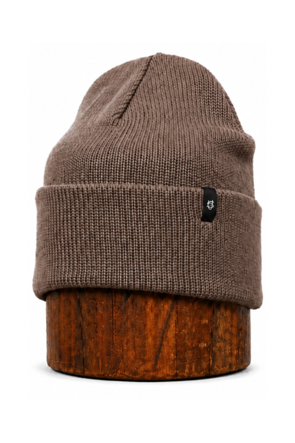 A brown ribbed knit beanie hat displayed on a wooden stand against a plain white background.