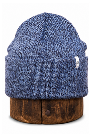 A blue marled knit beanie hat displayed on a round wooden stand against a plain white background.