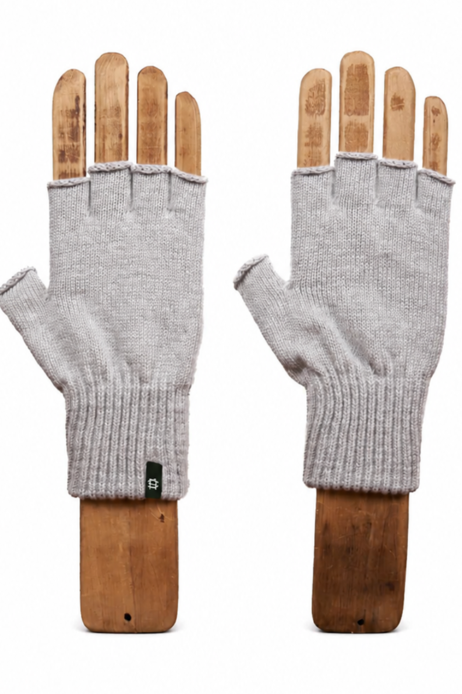 A pair of light gray knit fingerless gloves displayed on wooden mannequin hands against a plain white background.