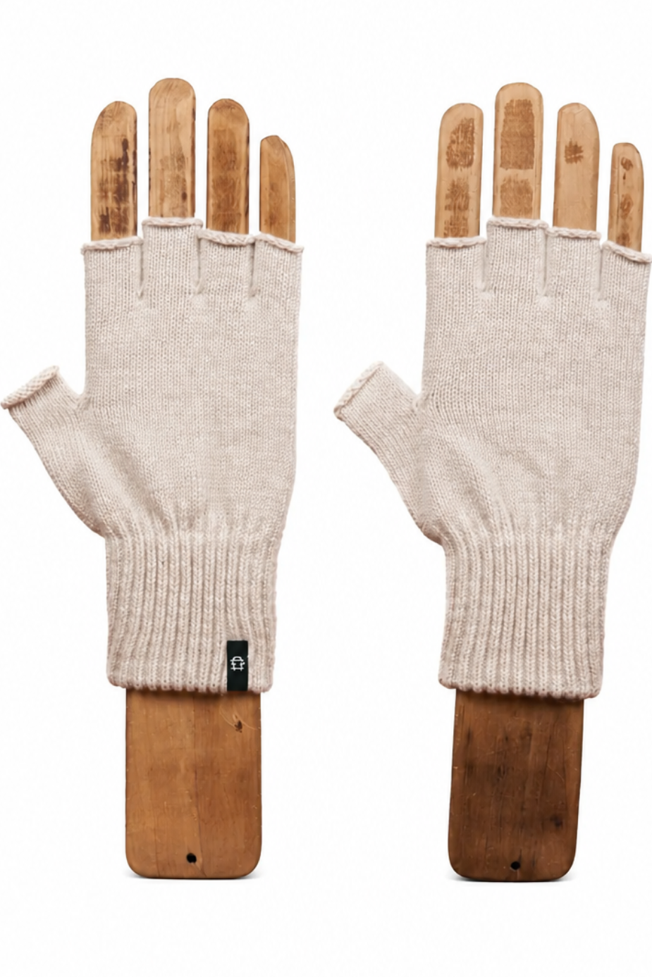 A pair of off-white knit fingerless gloves displayed on wooden hand forms against a plain white background.