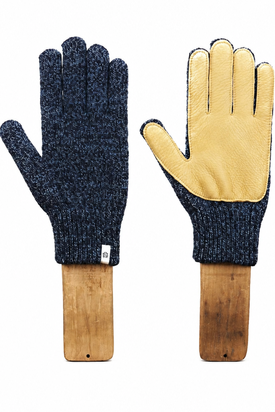 A pair of knit work gloves displayed side by side on wooden handles against a plain white background. One glove is dark navy blue knit, and the other shows a light tan leather palm with dark navy ribbed cuffs.