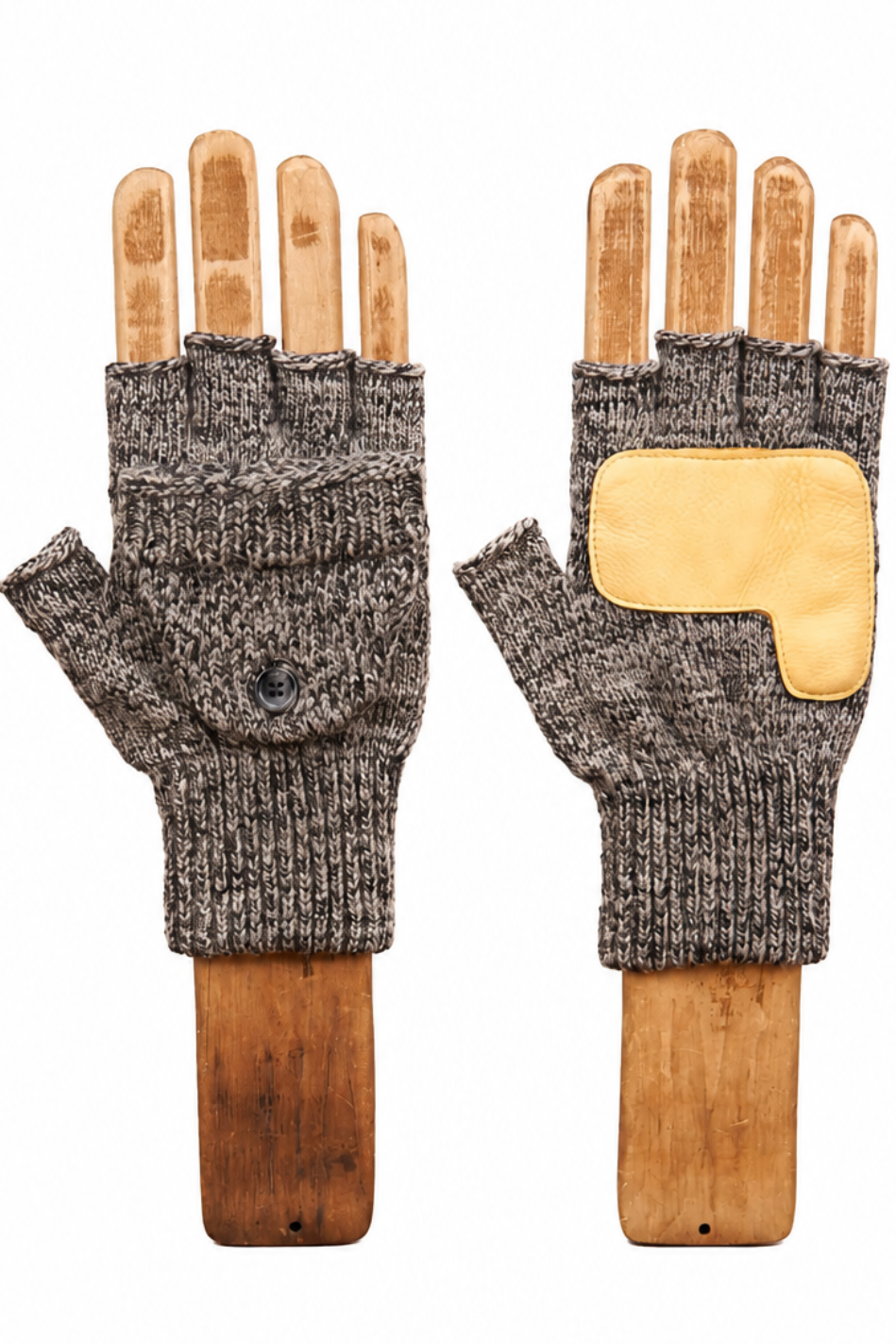 A pair of fingerless knit gloves shown on wooden hand forms against a plain white background. The gloves are heathered dark gray with a contrasting light tan patch on the back of one glove.