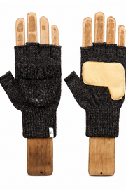 A pair of black fingerless knit gloves displayed on wooden hand-shaped mannequins against a plain white background. One glove shows the black ribbed knit body with a small metal snap button, and the other shows a light tan leather patch on the back of the hand.