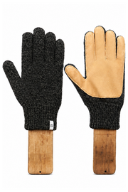 A pair of knit winter gloves displayed on wooden mannequin forms against a white background. One glove is shown palm-side with a dark charcoal heathered knit body and tan leather palms, and the other is shown back-side with the same dark knit and a tan leather cuff.