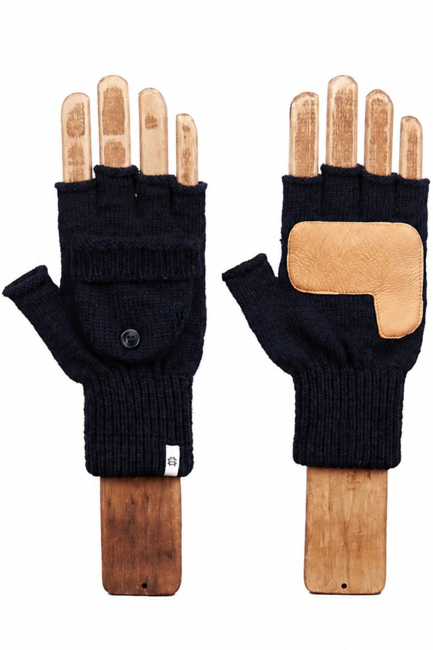 A pair of black fingerless knit gloves displayed on wooden hand forms against a plain white background. One glove is shown palm-side with a small black button, and the other is shown back-side with a tan leather patch on the back of the hand.