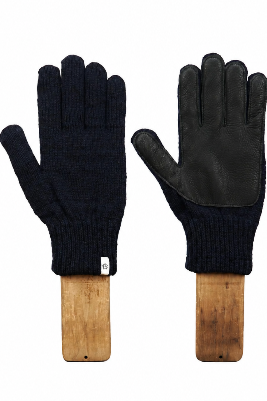 A pair of black knit and leather gloves displayed side-by-side on wooden hangers against a plain white background.