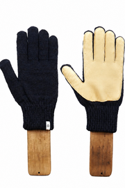 A pair of knit work gloves displayed side by side on wooden handles against a plain white background. One glove shows the dark navy blue knit back, and the other shows the light beige palm side with dark trim.