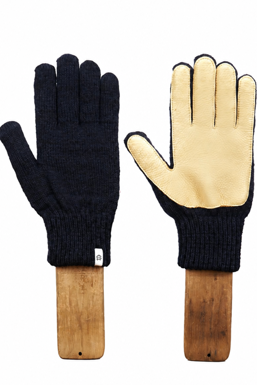 A pair of knit work gloves displayed side by side on wooden handles against a plain white background. One glove shows the dark navy blue knit back, and the other shows the light beige palm side with dark trim.