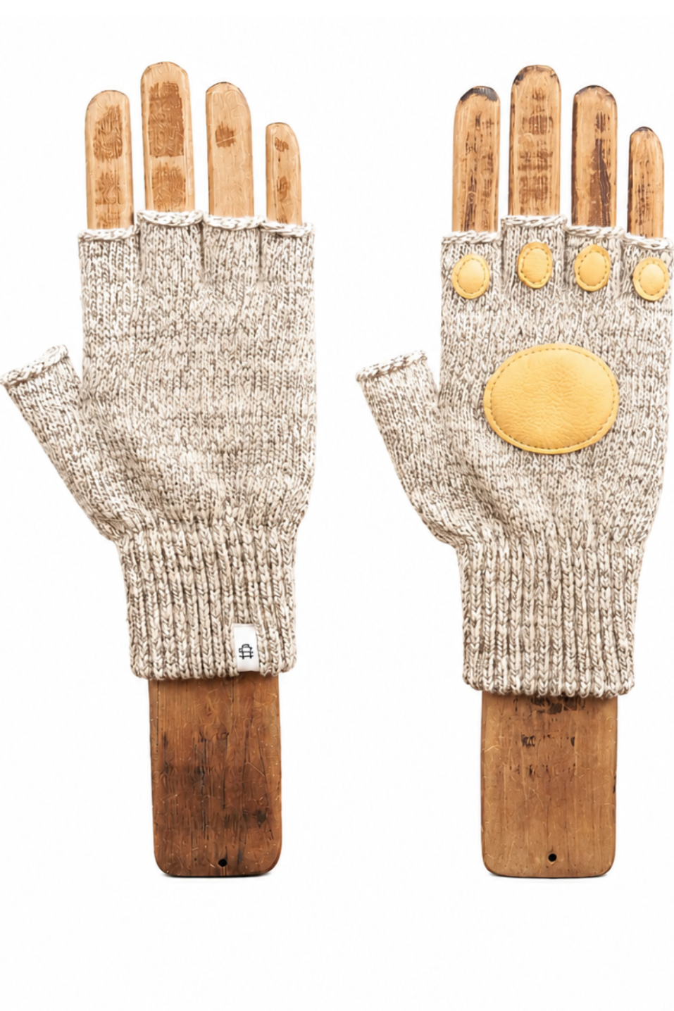 A pair of beige knit fingerless gloves displayed on wooden mannequin hands against a plain white background. One glove shows the knit texture and ribbed cuff, while the other shows the back with a large circular yellow patch and three smaller oval patches on the back of the hand.