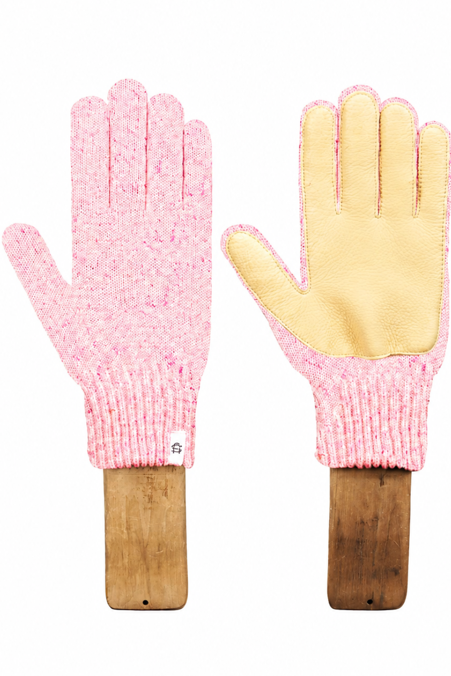 A pair of knit work gloves displayed on wooden handles against a white background. One glove is shown from the back, featuring a pink marled knit body, and the other is shown from the front, featuring a light yellow leather palm and matching pink marled knit cuff.