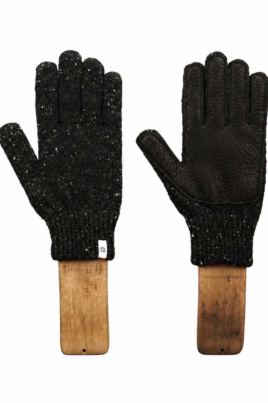 A pair of black knit gloves with textured leather palms and backs, mounted on wooden display stands against a plain white background.