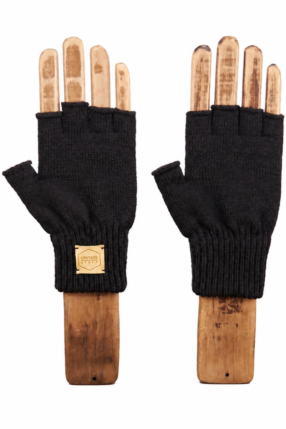 A pair of black fingerless knit gloves displayed on wooden hand mannequins against a plain white background.