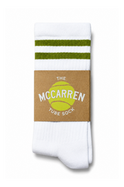 A pair of white tube socks with two green stripes near the top, wrapped in a brown paper band featuring a yellow tennis ball graphic and the text 'THE MCCARREN TUBE SOCK'.