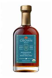 A bottle of Crown Maple Madagascar Vanilla organic maple syrup on a clean white background. The bottle is filled with amber liquid and features a teal label with gold and white text, topped with a metallic gold cap.